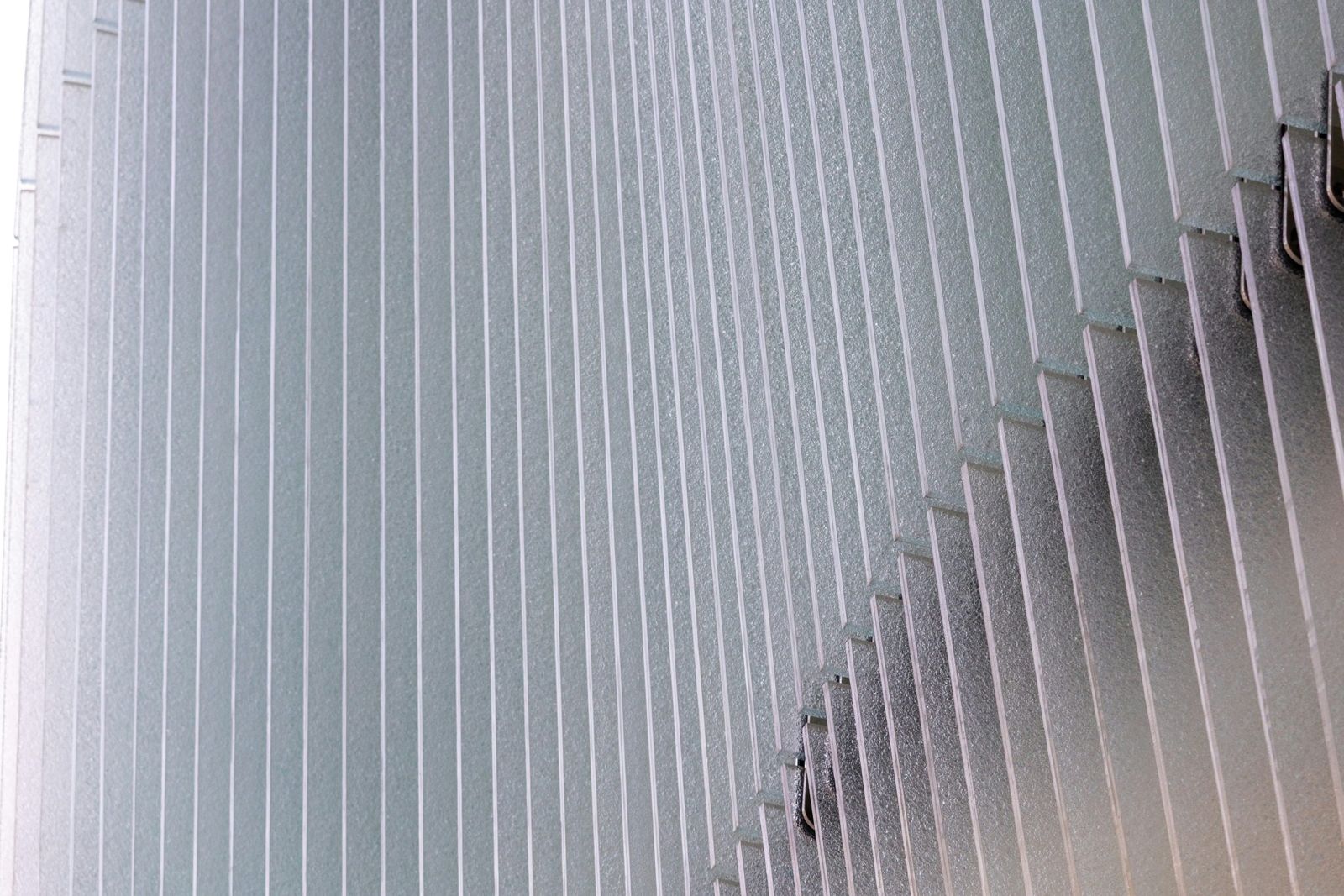 Rows of vertical frosted-glass fins diffusing daylight